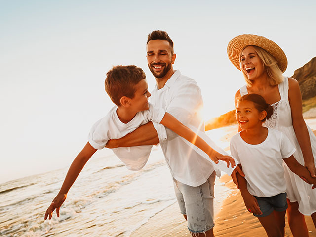 A happy family on the beach representing Kin and Co Property